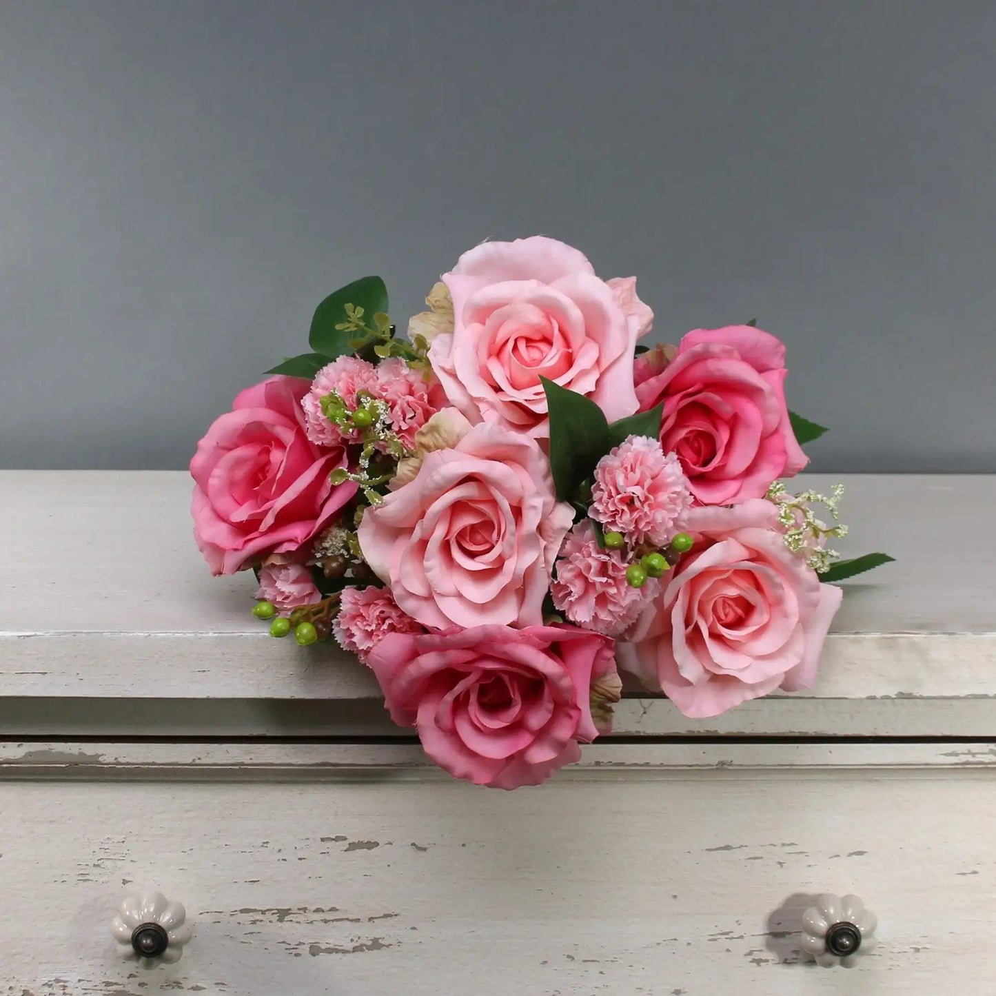 Pink rose and carnation bouquet for home décor or gift occasions, styled on rustic white furniture