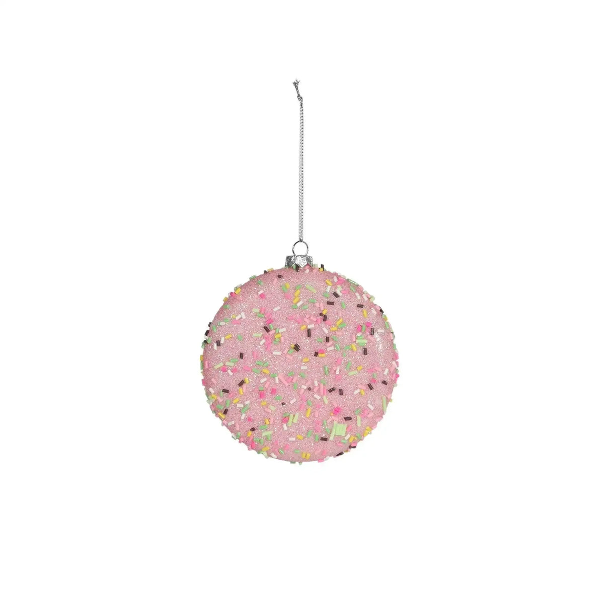 Pink Christmas ornament with colorful sprinkles and hanging silver string on white background