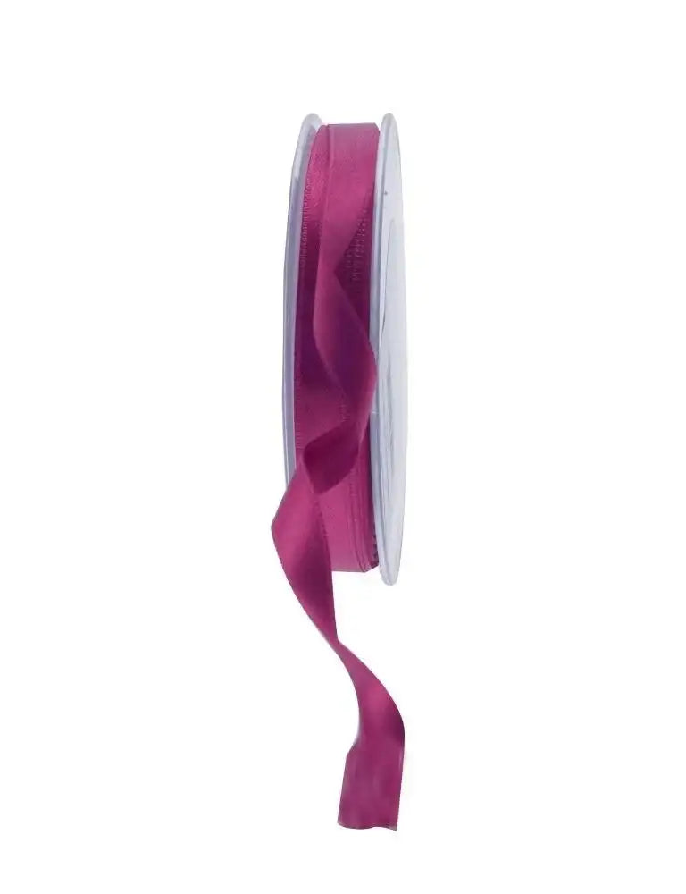 Deep pink satin ribbon on spool for gift wrapping and home décor accents