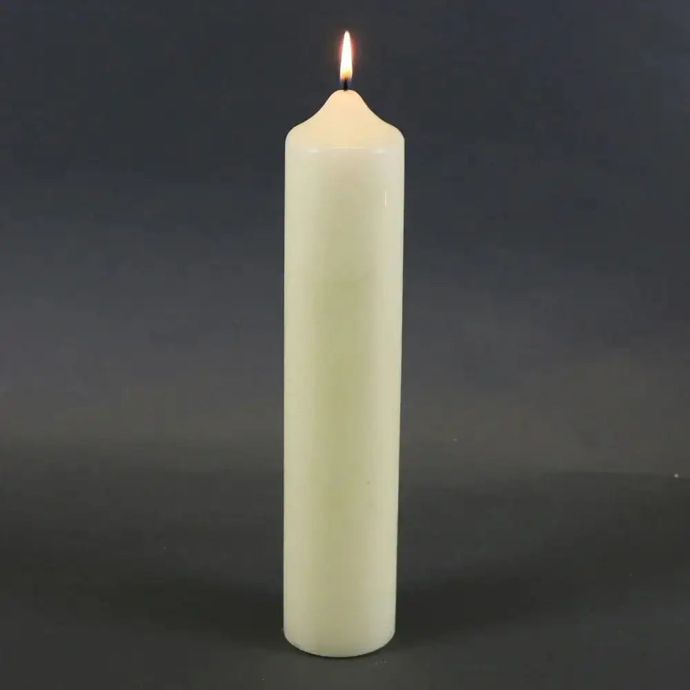 Lit white pillar candle for home décor and celebrations, perfect for creating cozy ambiance.