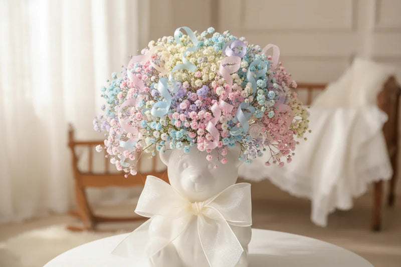 Pastel baby's breath bouquet with ribbons in a bear-shaped vase, nursery decor