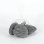 Smooth gray decorative pebbles in a white mesh bag on a plain background