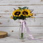 Sunflower bouquet with lavender ribbon in glass vase on rustic wood background
