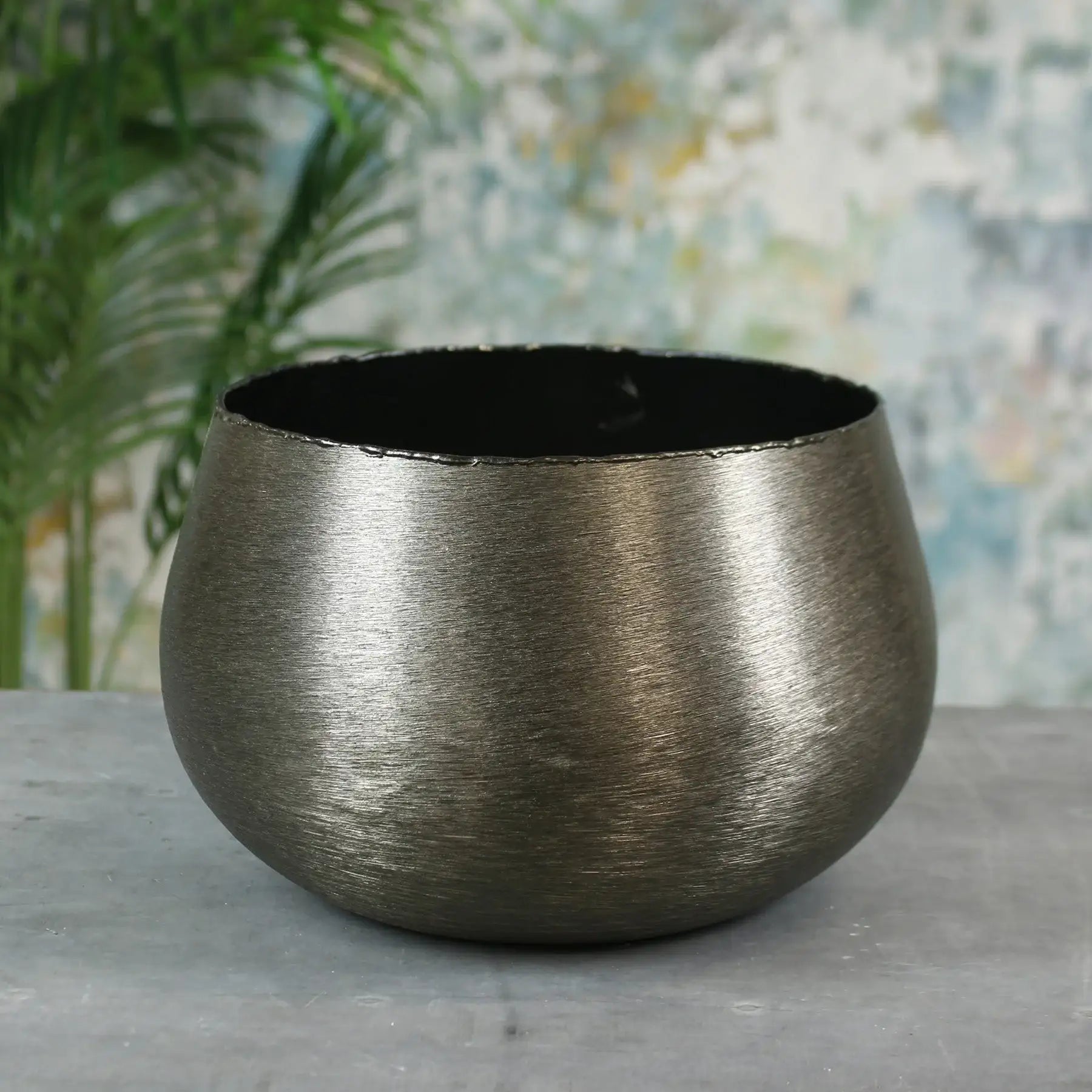 Brushed metal decorative bowl on grey surface, modern home décor accent piece