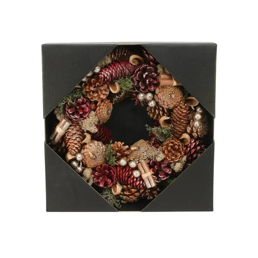 Festive pinecone wreath with red and gold accents in a black gift box, home décor