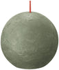 Round textured green decorative candle with red wick, home décor accent.