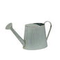 Galvanized metal watering can with ribbed texture on white background, garden décor