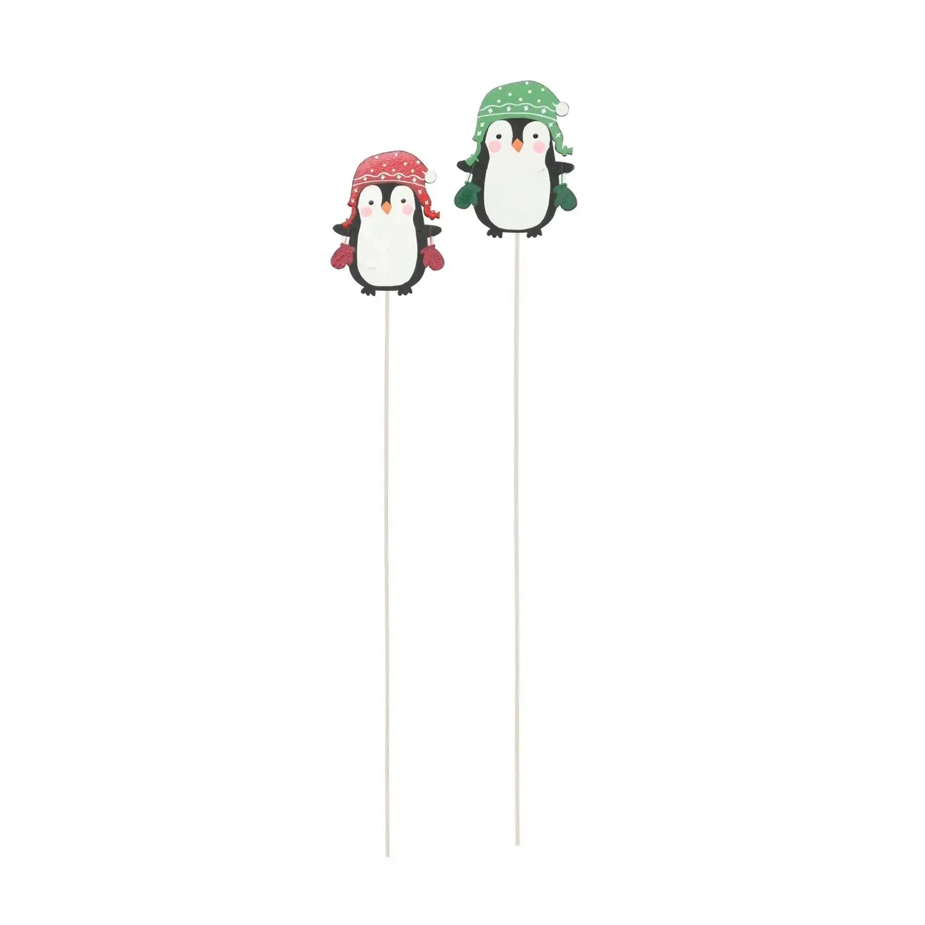 Two festive penguin cake toppers with red and green winter hats on white sticks