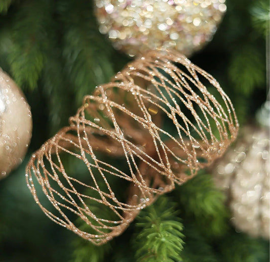 Gold glitter wire ornament on Christmas tree with festive baubles and green branches