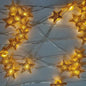 Golden star string lights glowing, perfect for festive home décor or celebrations.