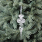 Clear glass icicle ornament hanging on a Christmas tree with green pine needles