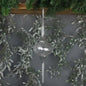 Clear glass Christmas tree ornament hanging from pine garland with silver holiday decor