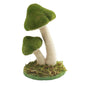 Felt mushroom decor with green caps and white stems on a mossy base, whimsical home accent
