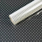 Polka dot cellophane gift wrap roll on black background, ideal for gift packaging and crafts.