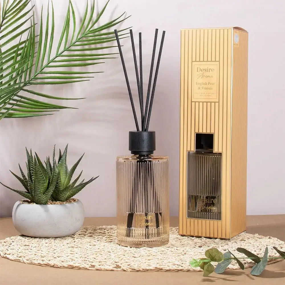 Reed diffuser set with English pear and freesia scent, in a modern home décor setting with plants.
