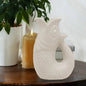White ceramic fish figurine on wooden table with candle and plant, home decor accent