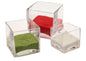 Three clear glass cube vases with red, green, and white decorative sand