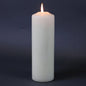 Lit white pillar candle for home décor and celebration ambiance
