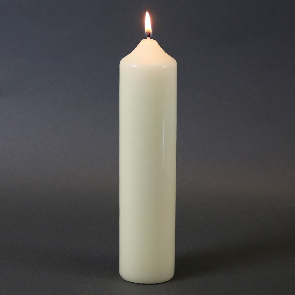Lit white pillar candle for home décor and celebrations, creating warm ambiance
