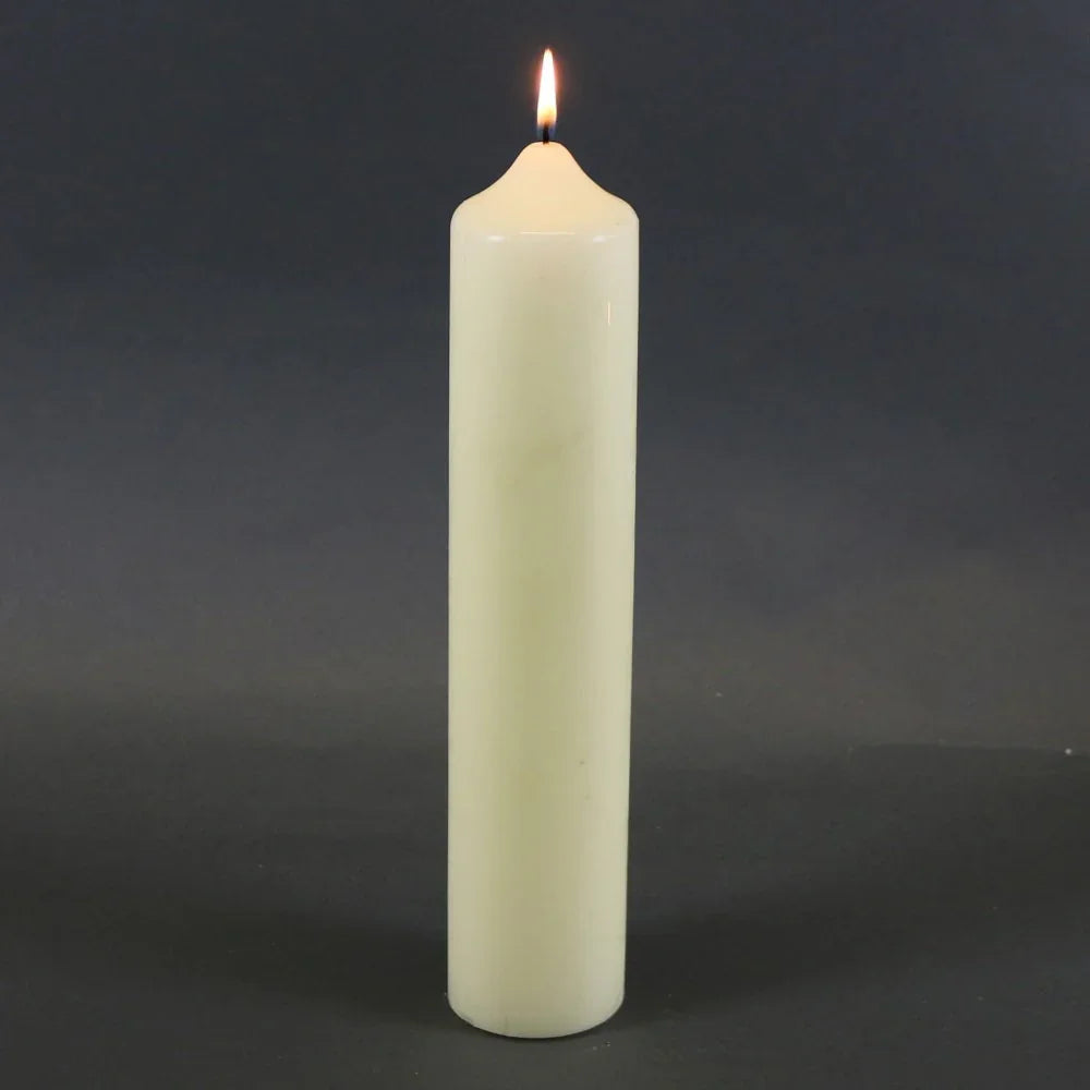 Lit white pillar candle for home décor and celebrations, perfect for creating cozy ambiance.