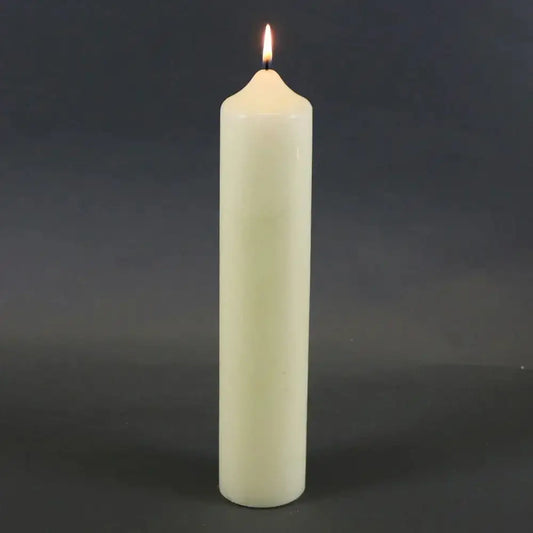 Lit white pillar candle for home décor and celebrations, perfect for creating cozy ambiance.
