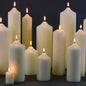 Lit white pillar candles in varying heights for home décor and cozy ambiance