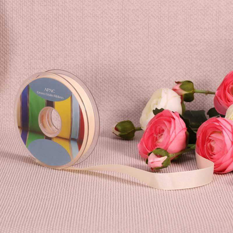 Cream grosgrain ribbon spool with pink and white roses, perfect for luxury gift wrapping and home décor accents.