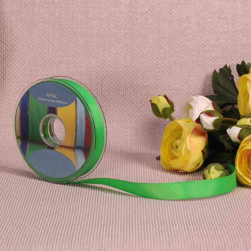 Vibrant green grosgrain ribbon spool with yellow and white roses, perfect for luxury gift wrapping and home décor accents.