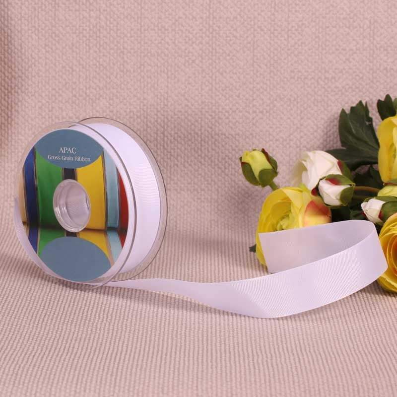 White grosgrain ribbon spool with yellow and white roses, perfect for luxury gift wrapping and home décor accents.